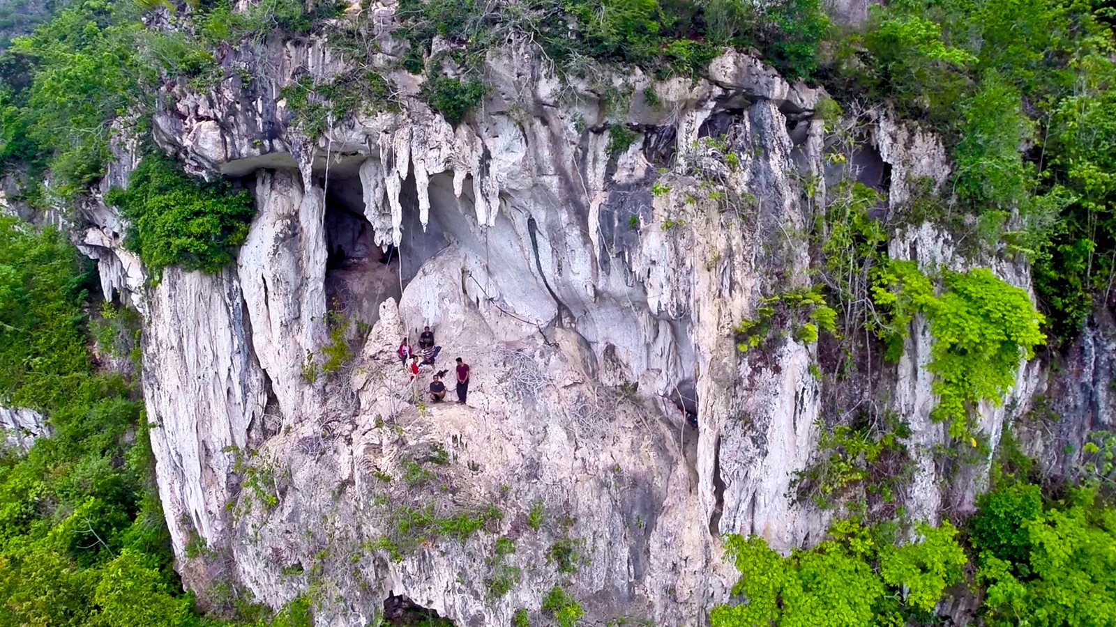An aerial view of a cave high in a limestone cliff, Sangkulirang–Mangkalihat karst, Borneo